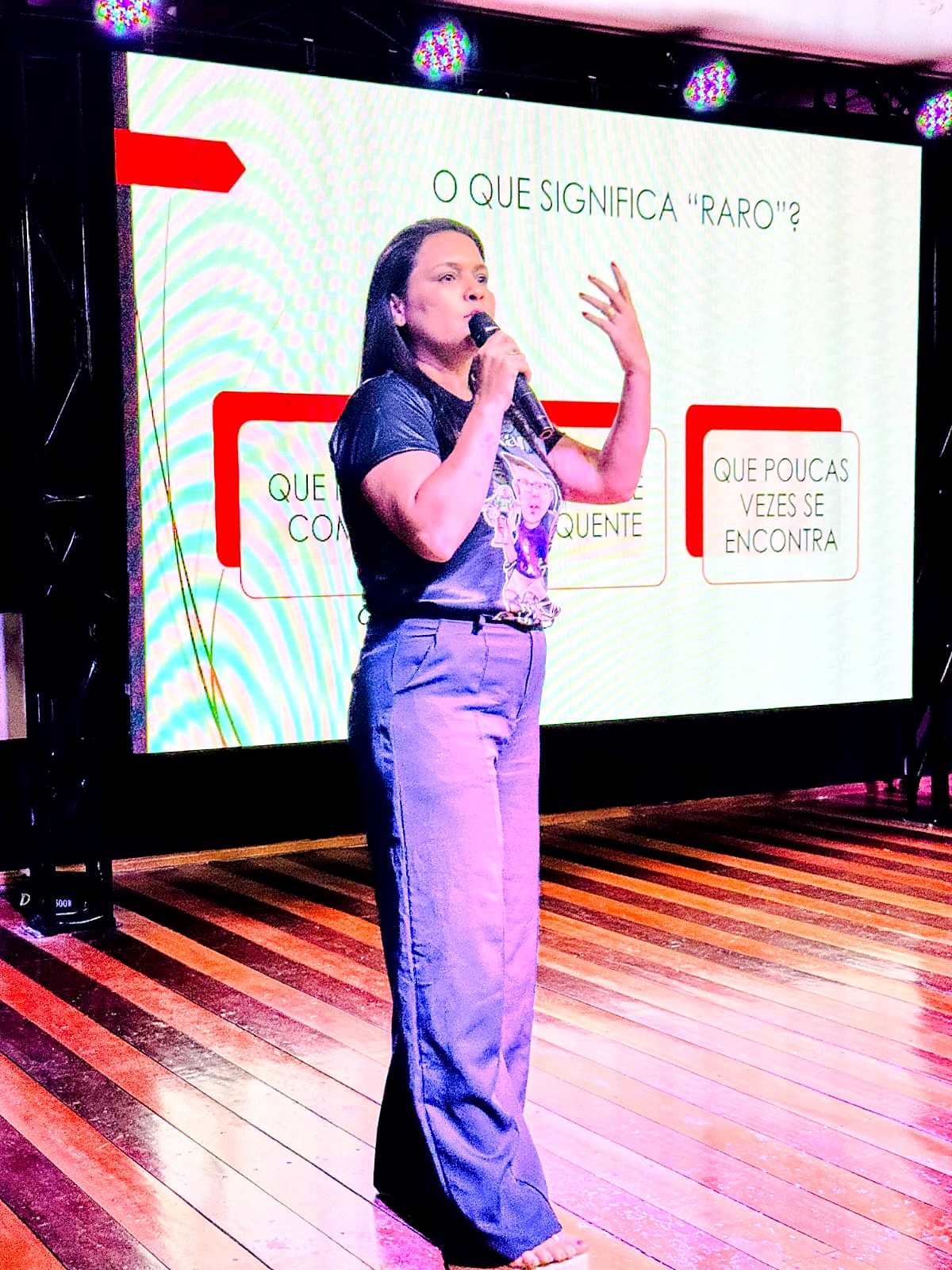 Palestrante no palco diante da apresentação com a pergunta O que significa raro?