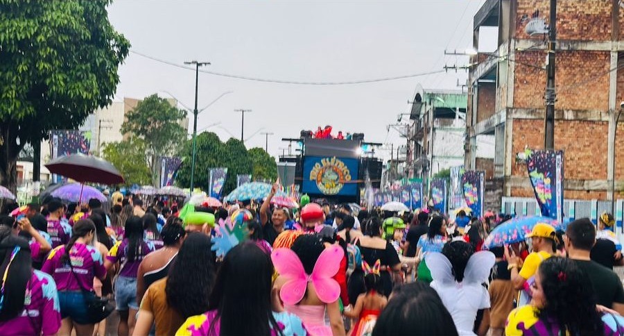 Público com guarda-chuvas coloridos acompanhando o Carnararos na avenida