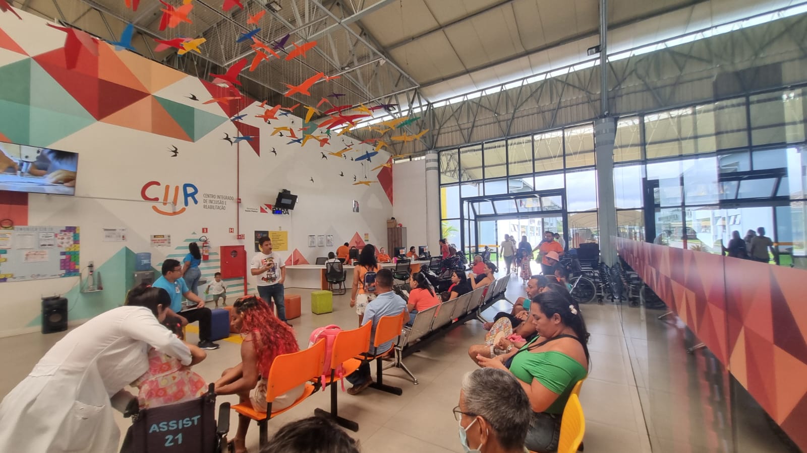 Público reunido no saguão do CIIR, com o letreiro do Centro Integrado de Inclusão e Reabilitação ao fundo